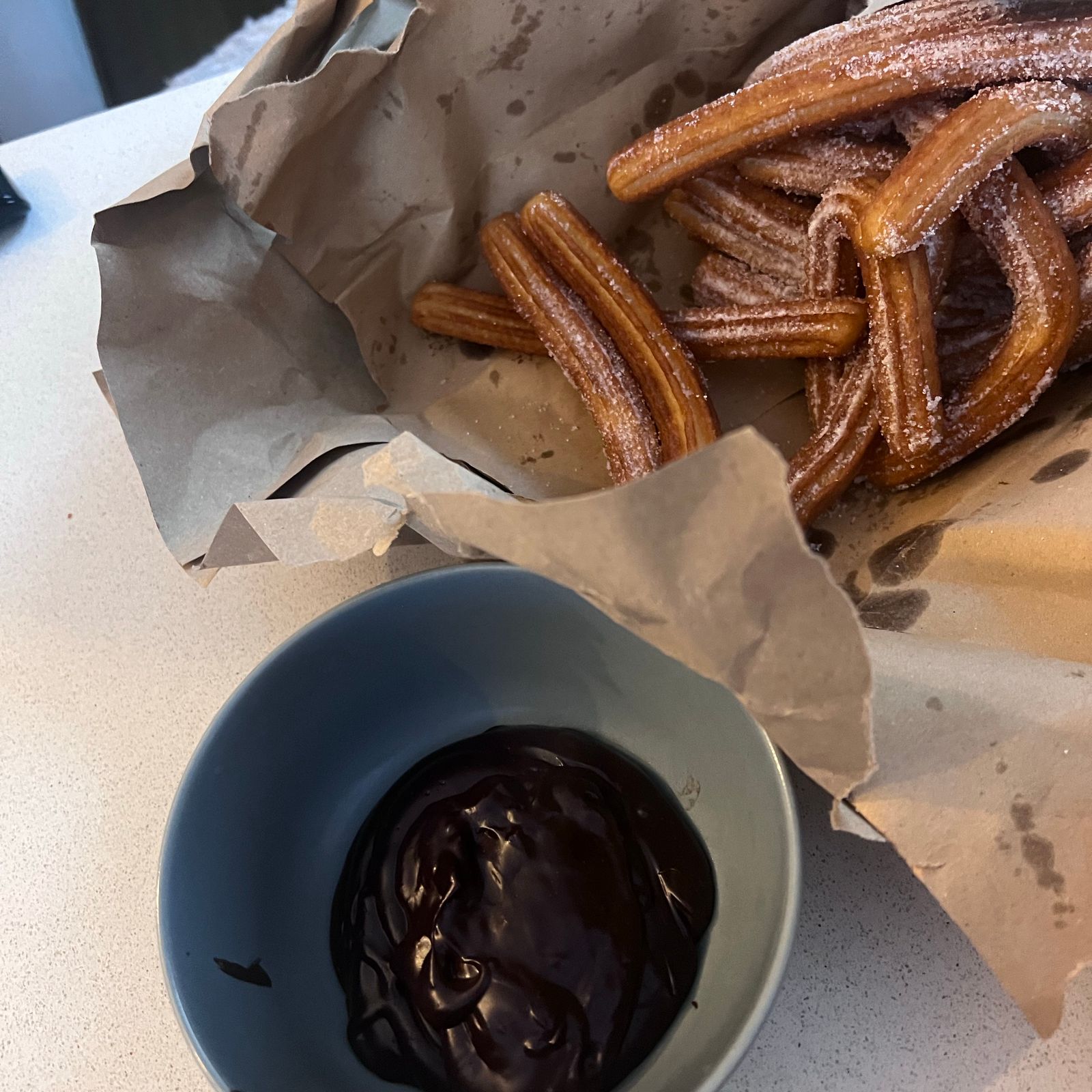 Cinnamon sugar churros with a bowl of dark chocolate